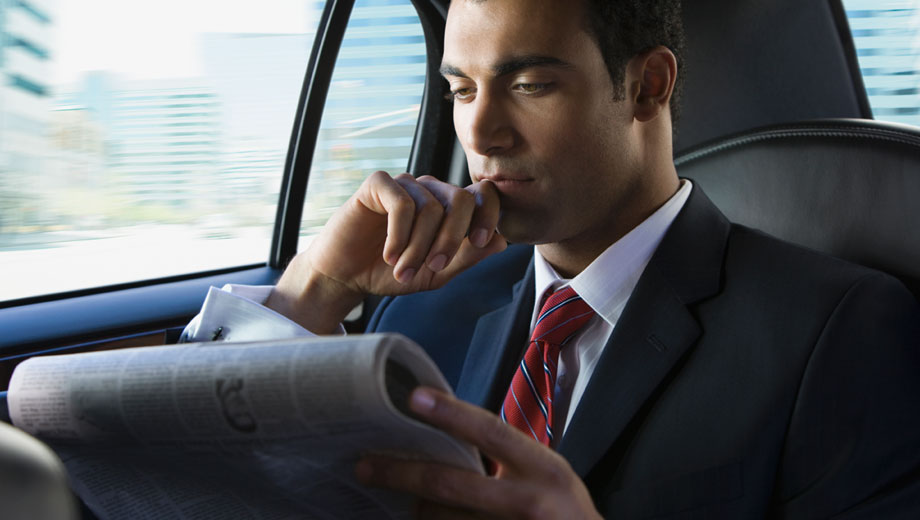 Mężczyzna czytający gazetę w samochodzie